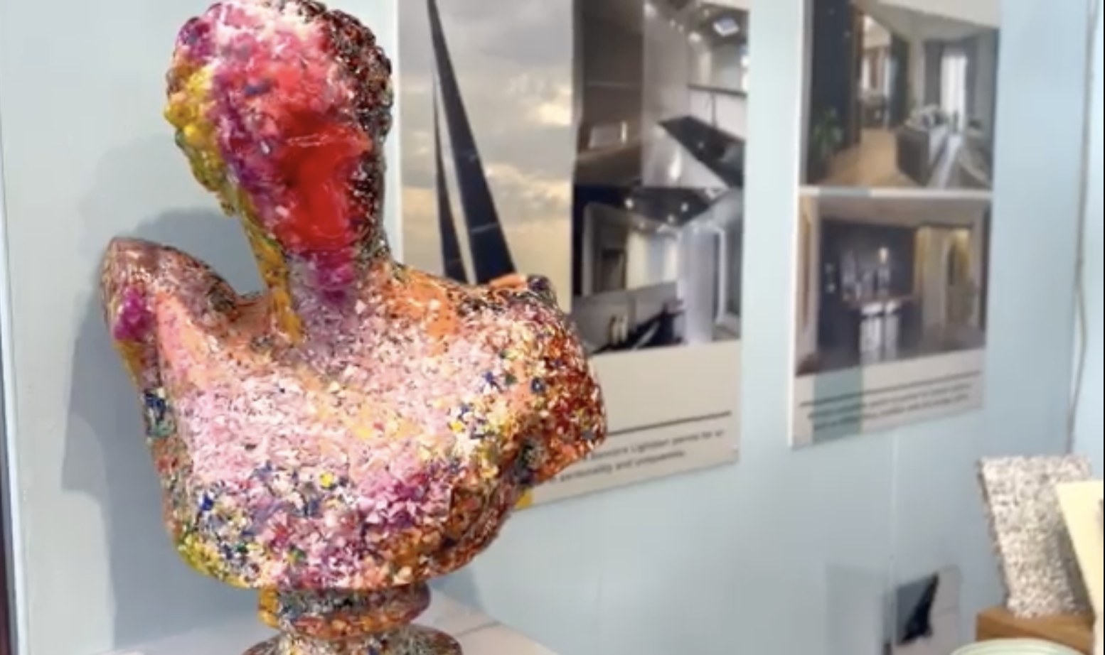 Busto colorido hecho de fragmentos de plástico reciclado expuesto en una feria de compuestos