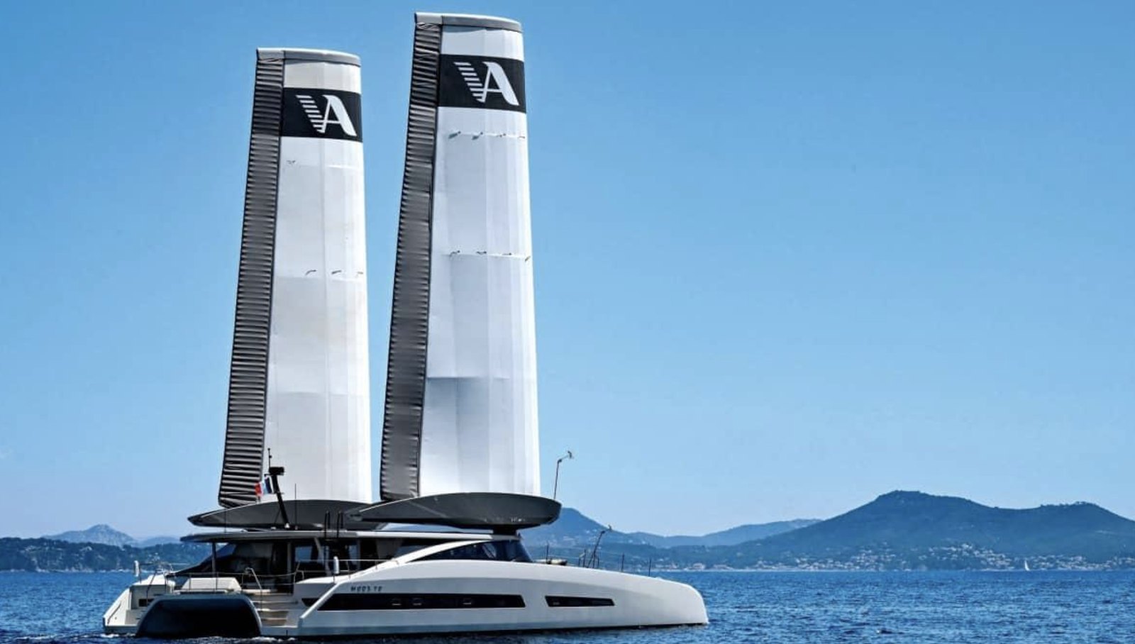 Catamarán MODX 70 navegando con dos alas verticales blancas en lugar de velas